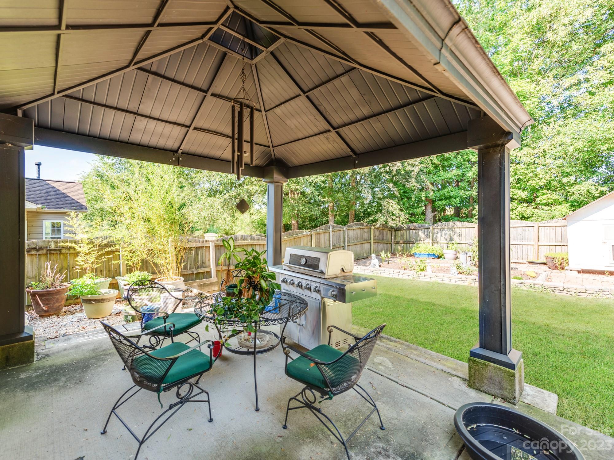 4409 Lawrence Daniel Drive Matthews, NC 28104 - Photo 37 of 38 a view of a chair and tables in the patio with a garden