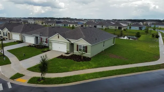 a aerial view of a house with a yard and lake view