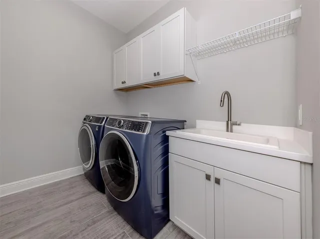 a utility room with sink dryer and washer