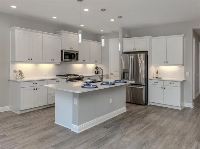 a kitchen with refrigerator cabinets and wooden floor