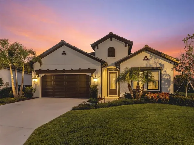 a view of a house with a yard and potted plants