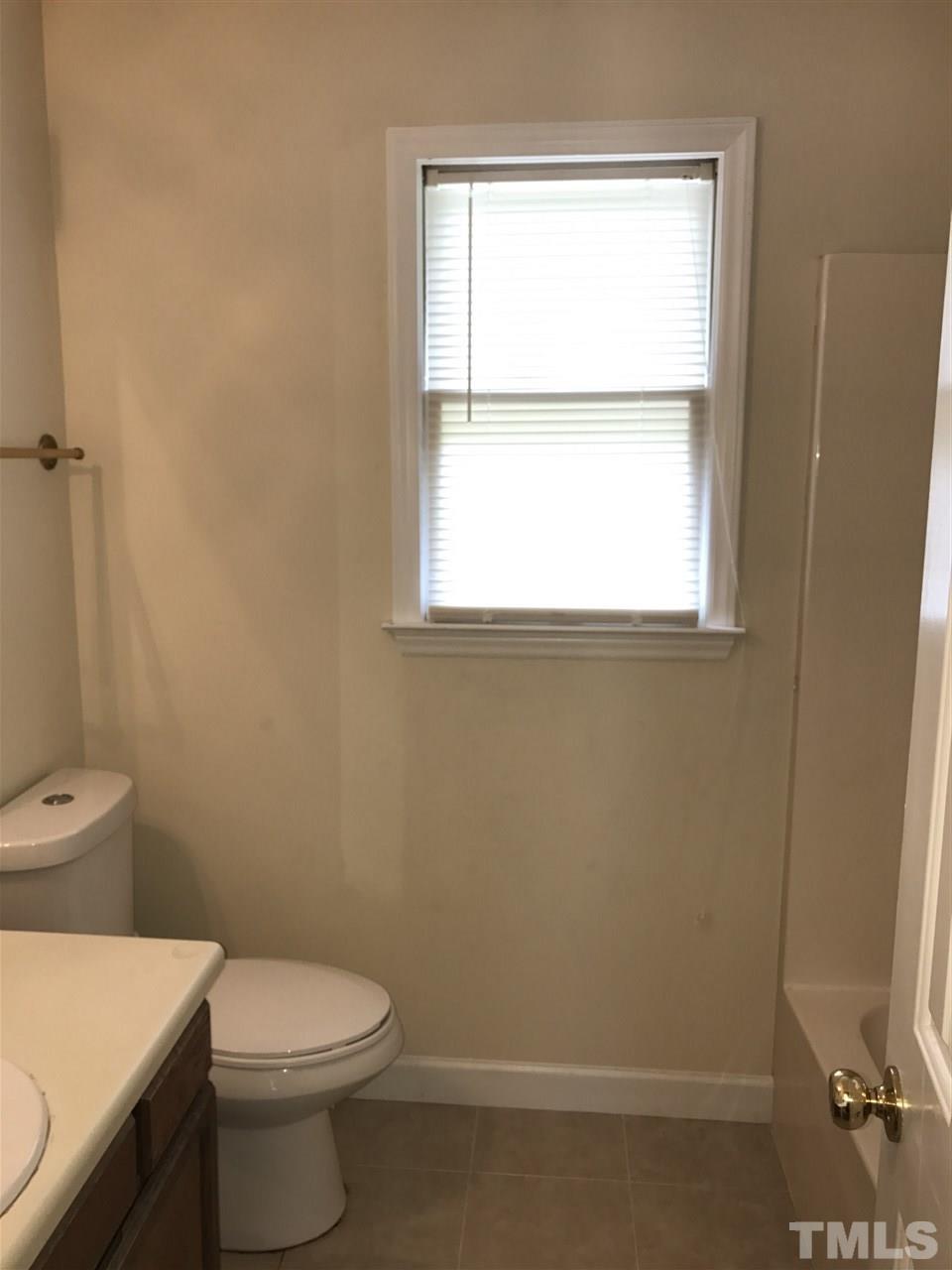1728 Vintage Road Raleigh, NC 27610 - Photo 12 of 16 a white toilet sitting next to a window in a bathroom