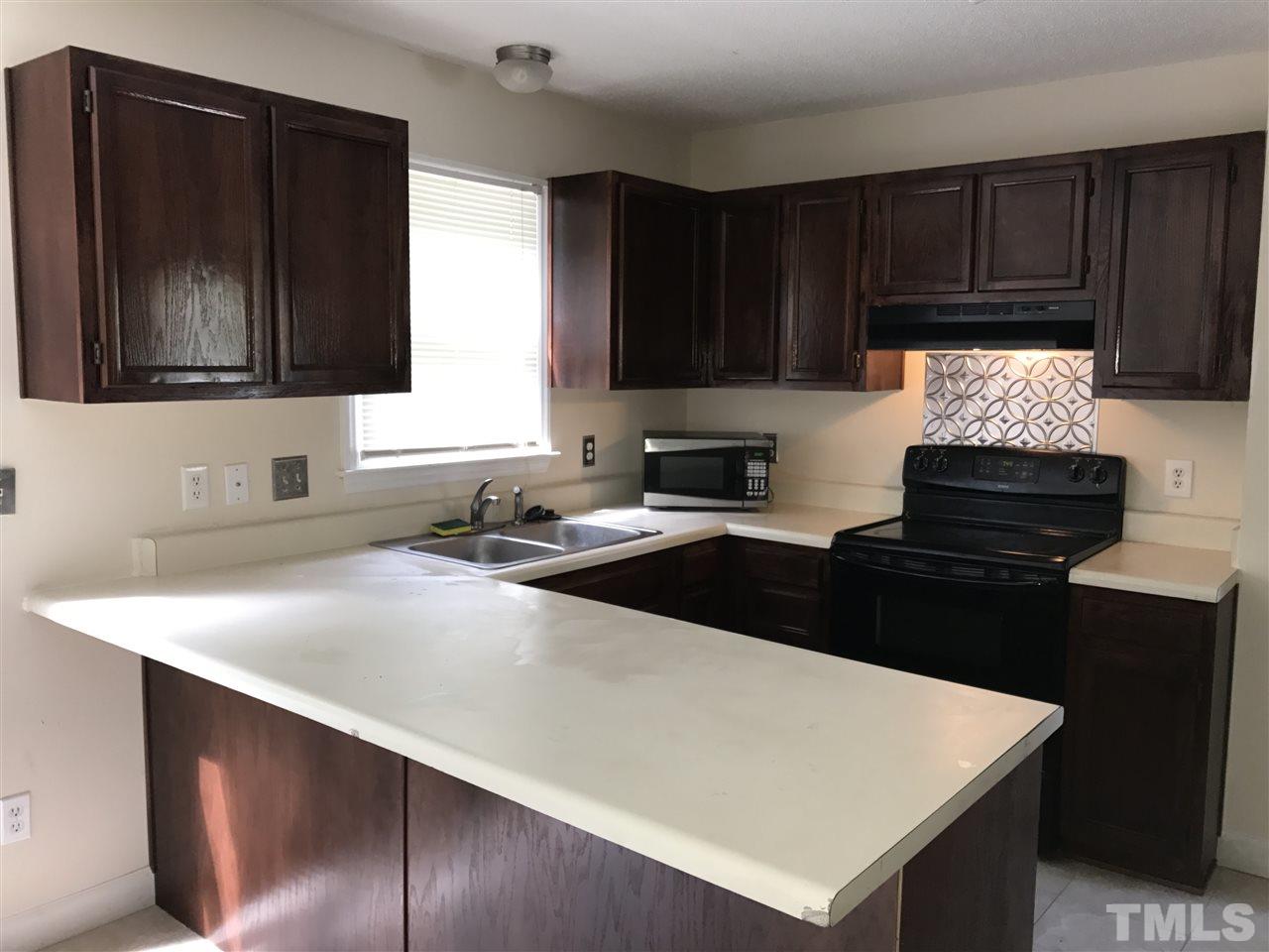 1728 Vintage Road Raleigh, NC 27610 - Photo 5 of 16 a kitchen with granite countertop a stove a sink and a microwave