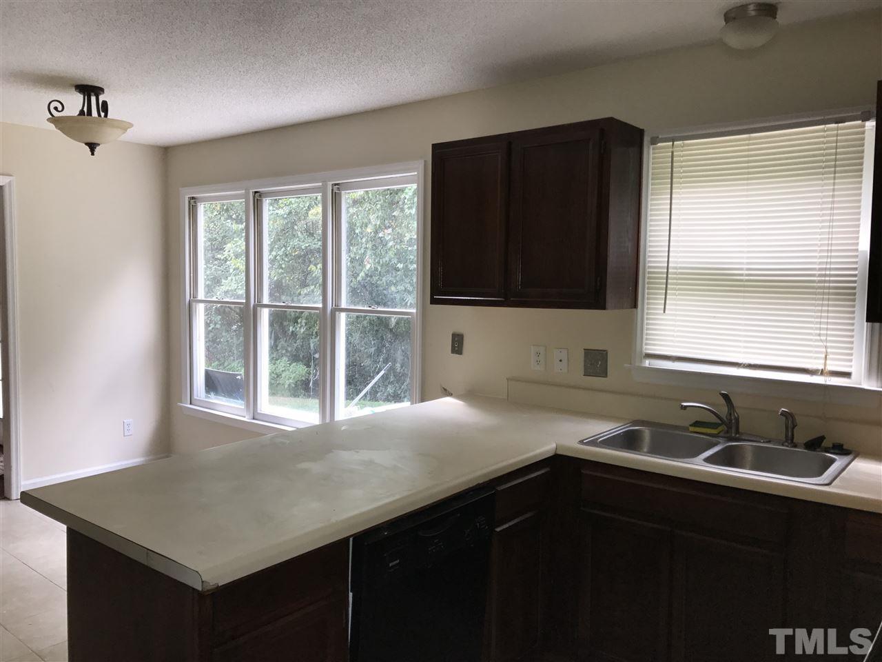 1728 Vintage Road Raleigh, NC 27610 - Photo 7 of 16 a kitchen with a sink a window and a refrigerator