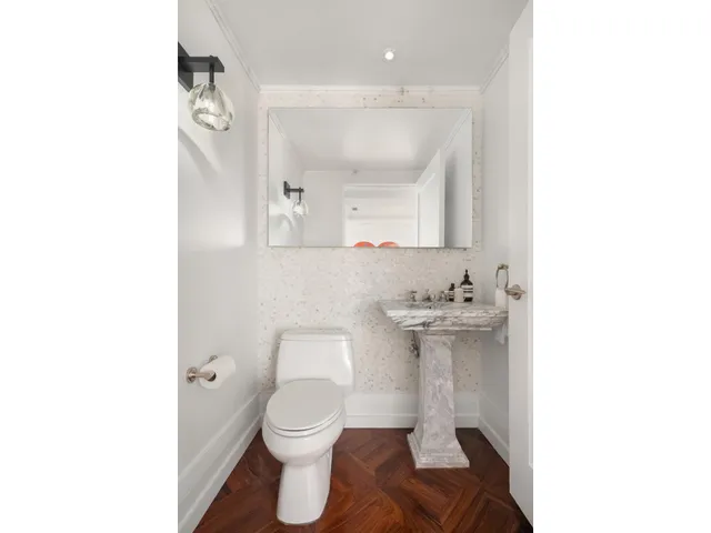 a bathroom with a sink toilet and mirror