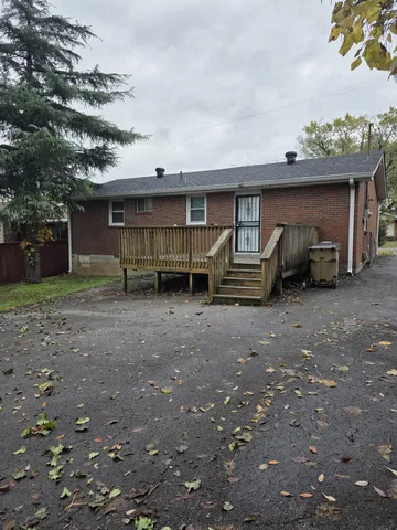 a view of a house with a yard and parking space