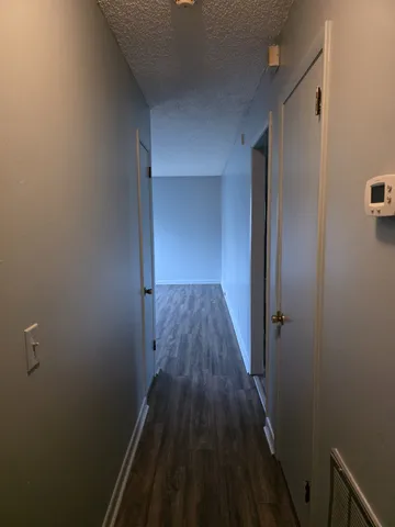 a view of a hallway with wooden floor and staircase