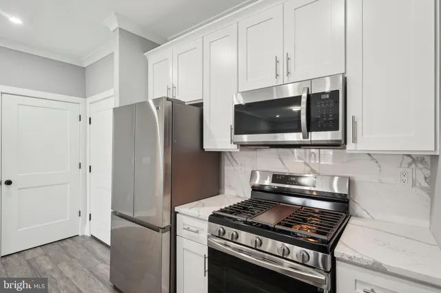 a kitchen with stainless steel appliances granite countertop a stove a refrigerator and a microwave
