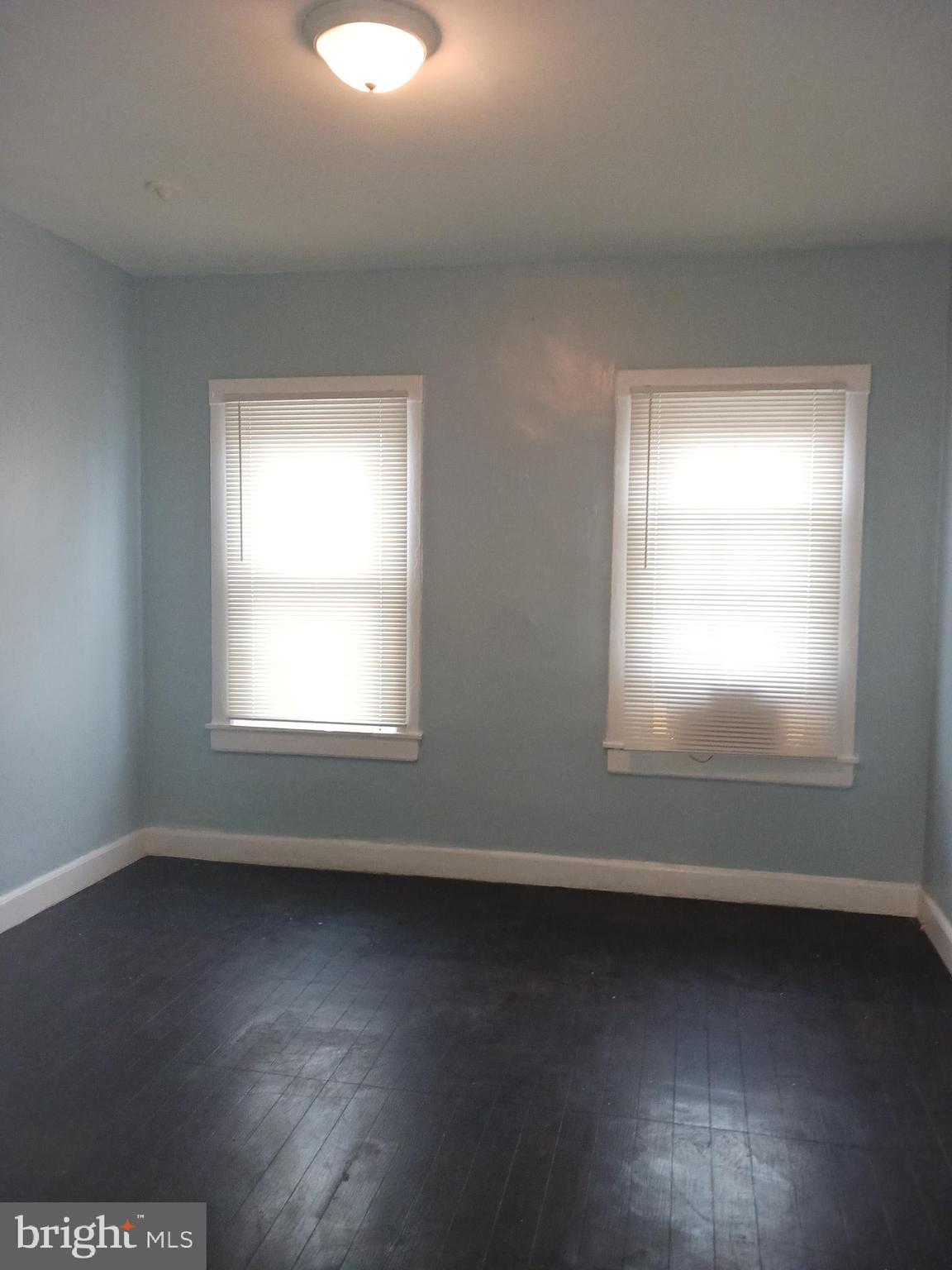 1708 Normal Avenue Baltimore, MD 21213 - Photo 12 of 14 an empty room with wooden floor and windows