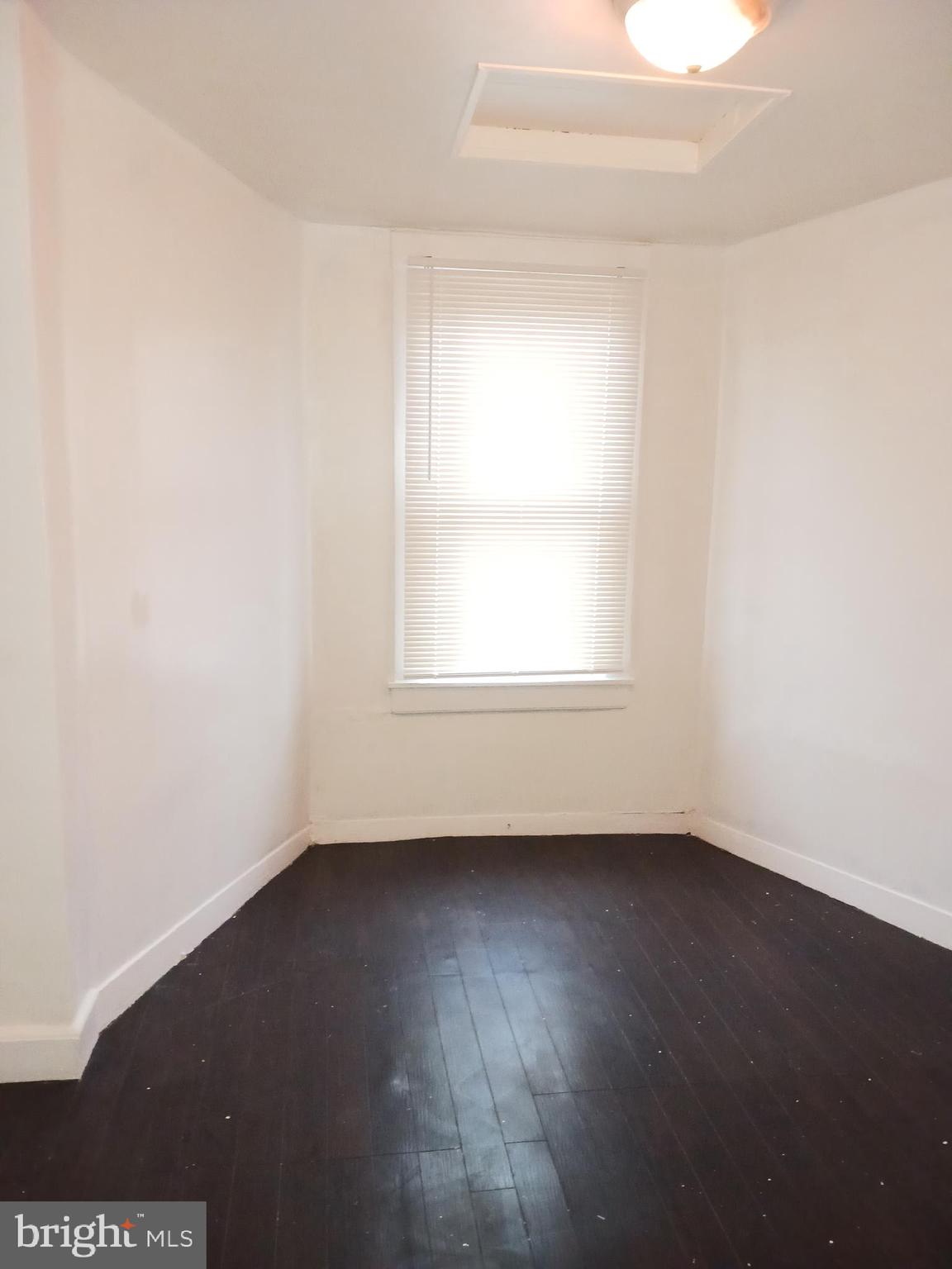 1708 Normal Avenue Baltimore, MD 21213 - Photo 9 of 14 an empty room with wooden floor and windows