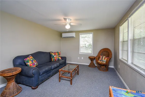 a living room with furniture a chandelier and a window