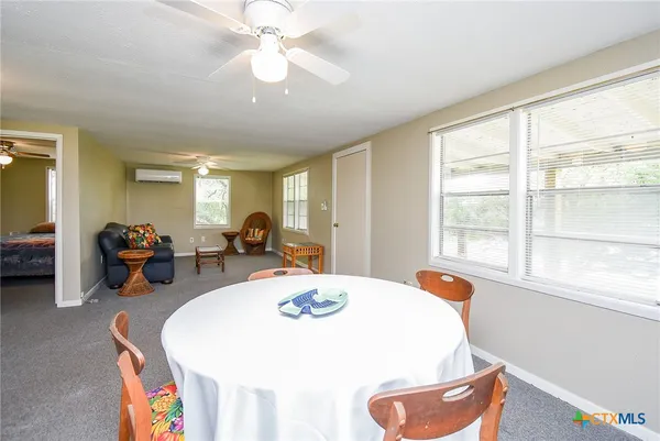 a living room with furniture a chandelier fan and a dining table