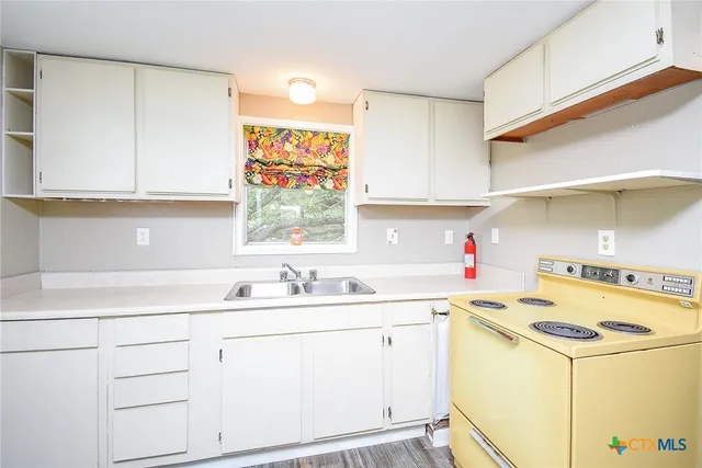 a kitchen with a sink stove and cabinets