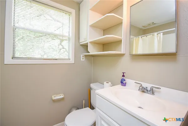 a white toilet sitting next to a bathroom sink