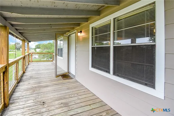 a hallway with wooden floor and windows