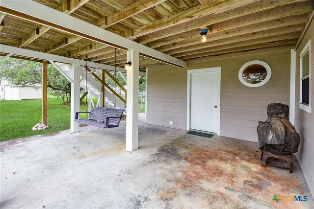 a view of a porch with a table and a chair