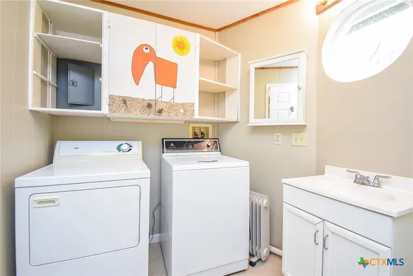 a view of washer and dryer with kitchen in the background
