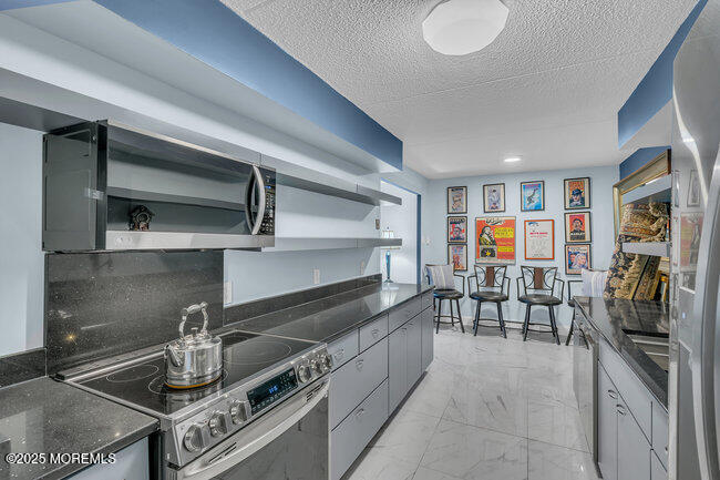 860 Lower Ferry Road, Unit 1K Ewing, NJ 08628 - Photo 13 of 49 a kitchen with stainless steel appliances granite countertop a stove and a sink