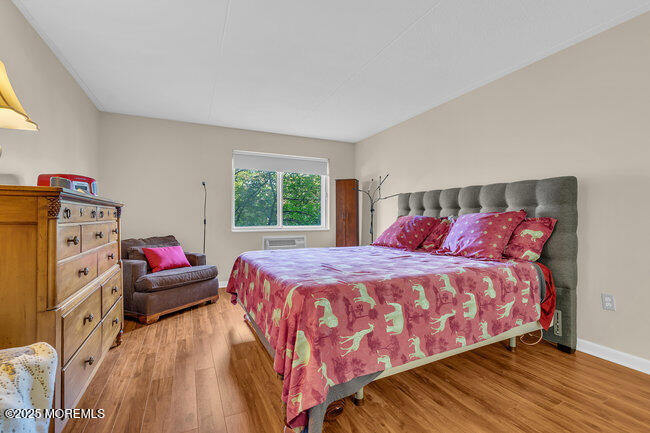860 Lower Ferry Road, Unit 1K Ewing, NJ 08628 - Photo 31 of 49 a bedroom with a bed and wooden floor