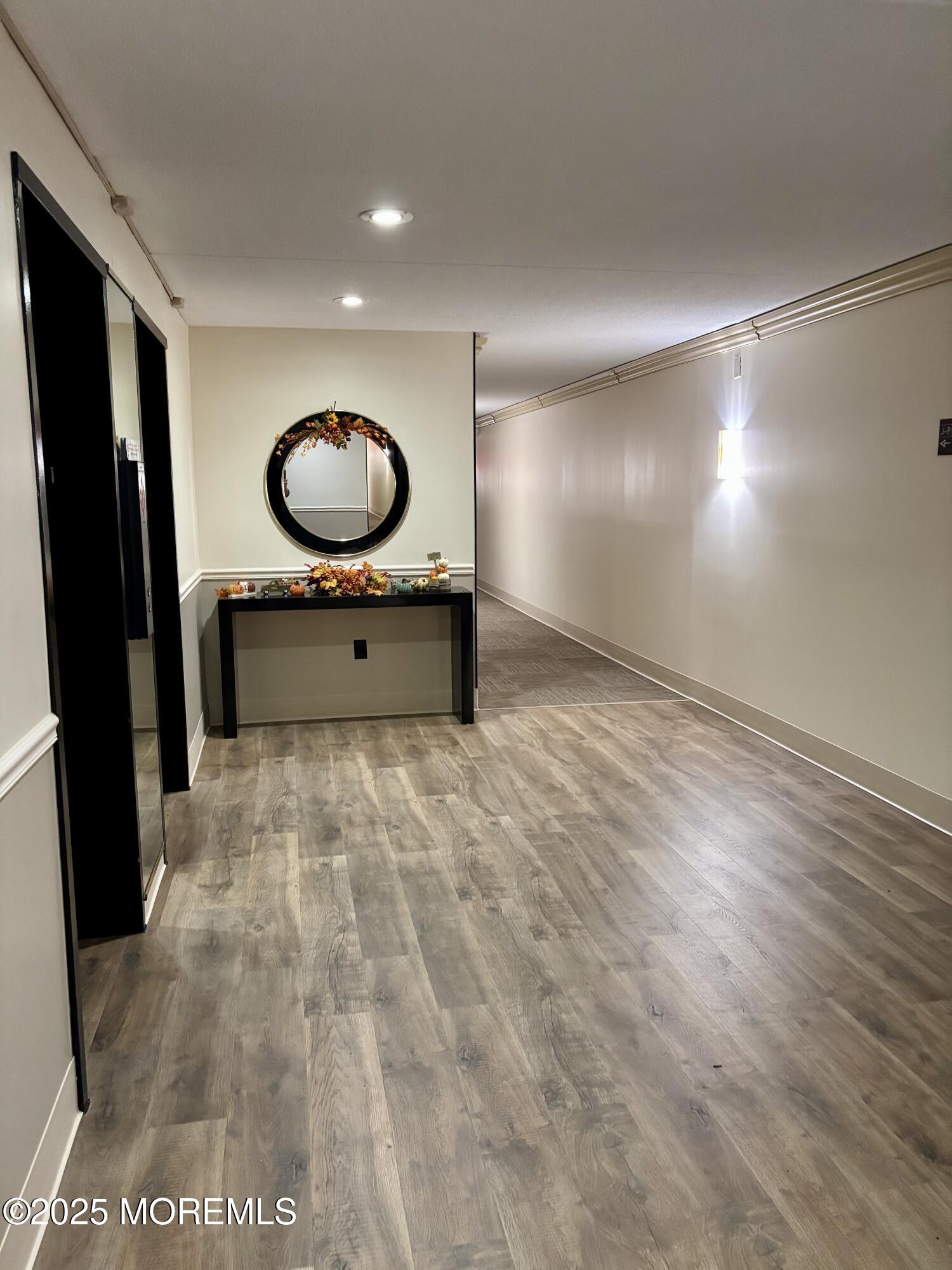 860 Lower Ferry Road, Unit 1K Ewing, NJ 08628 - Photo 6 of 49 a room with a mirror and a wooden floor