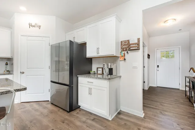 a kitchen with stainless steel appliances a refrigerator stove and wooden floor