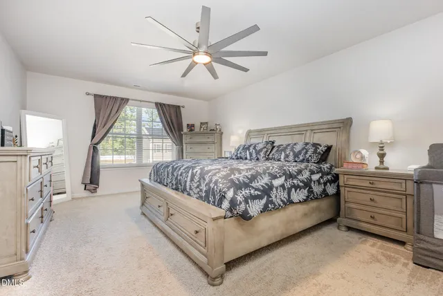 a bedroom with a large bed and a chandelier