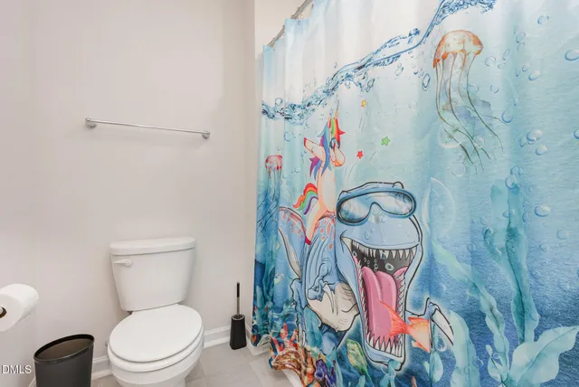 a bathroom with a toilet and a shower curtain