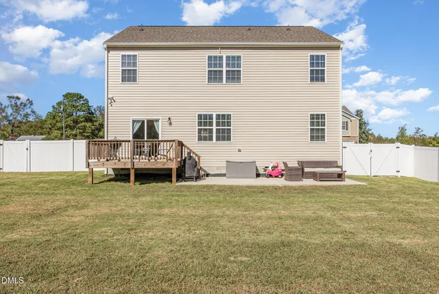 a view of a house with a patio and a yard