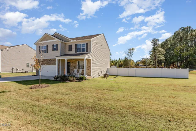 a front view of a house with yard and lake view
