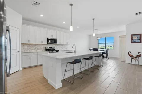 a kitchen with appliances a sink a counter top space and cabinets