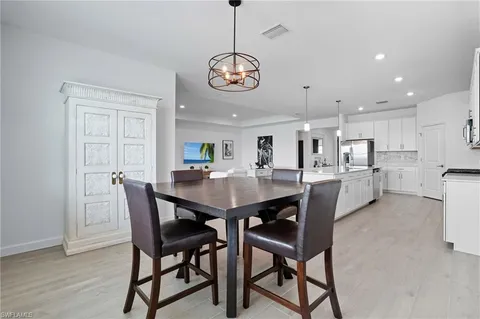 a large kitchen with stainless steel appliances kitchen island a stove a sink a center island and a wooden floor