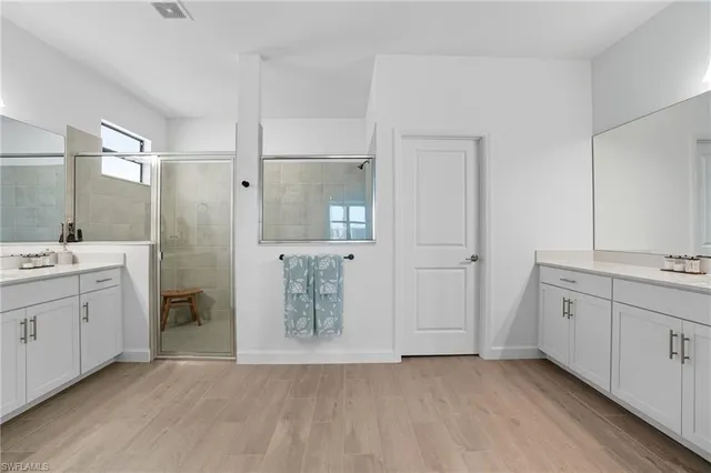 a bedroom with a bed a dresser and a large window