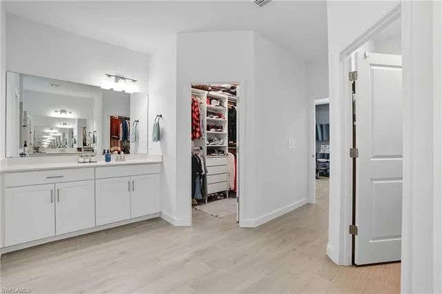 a bathroom with a double vanity sink a toilet and shower