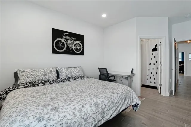 a bedroom with a bed and a painting on the wall