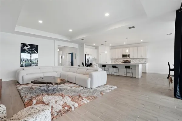 a living room with furniture and kitchen view