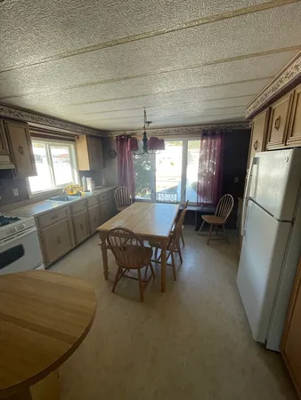 a living room with furniture wooden floor and a refrigerator