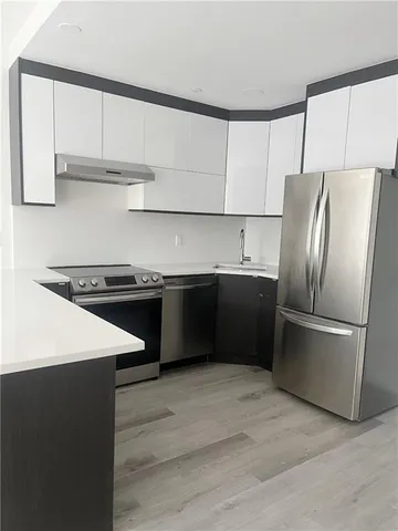 a kitchen with stainless steel appliances a refrigerator sink and cabinets