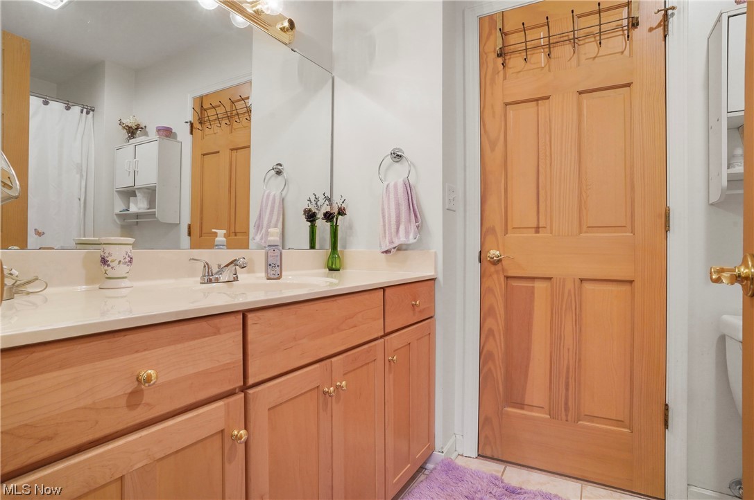 693 Timbercreek Road Northfield, OH 44067 - Photo 16 of 34 Bathroom with vanity, mirror, and light tile floors