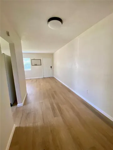 an empty room with a window and a fan