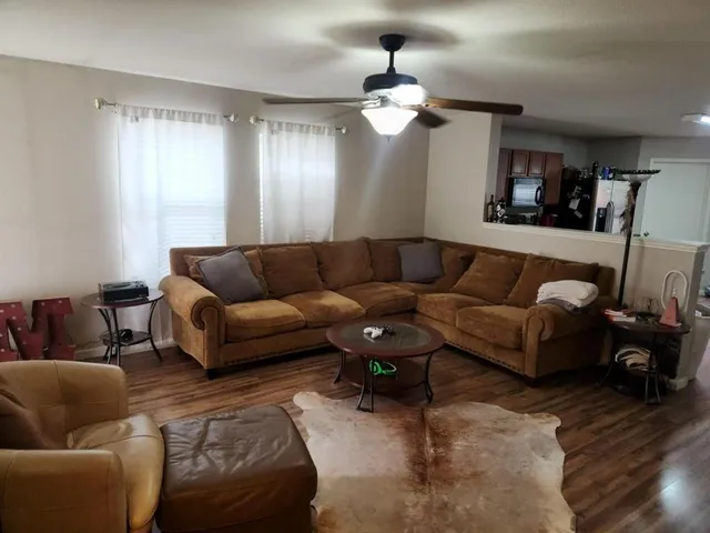 a living room with furniture a wooden floor and a chandelier