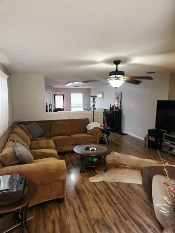 a living room with furniture and wooden floor