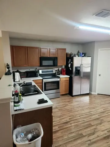 a kitchen with stainless steel appliances a stove a sink and a refrigerator