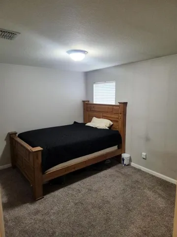a bedroom with a bed and a night stand