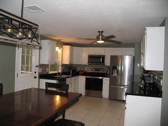 a kitchen with stainless steel appliances granite countertop a sink dishwasher stove and refrigerator