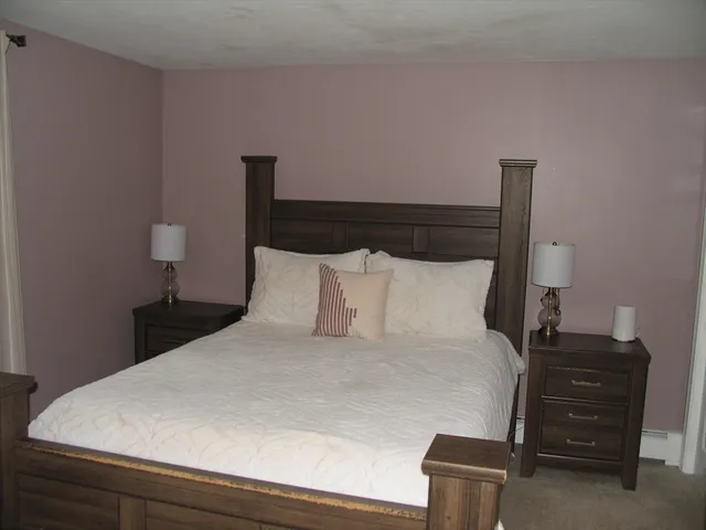 a large bed sitting in a bedroom next to a lamp