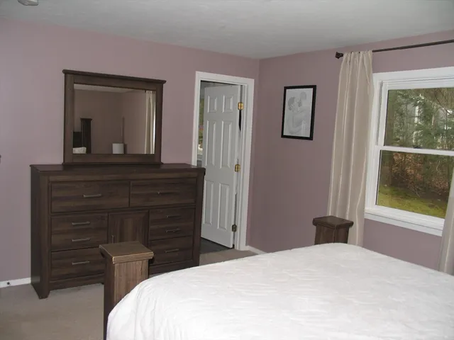 a bedroom with a bed and a large mirror