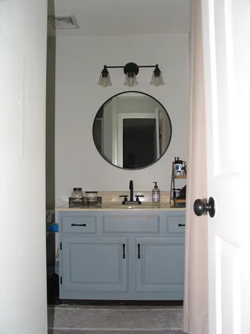 a bathroom with a granite countertop sink and a mirror