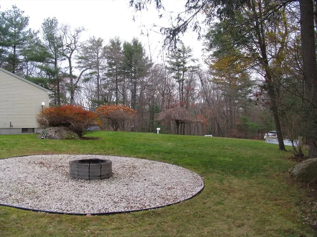 a view of a house with backyard and trees
