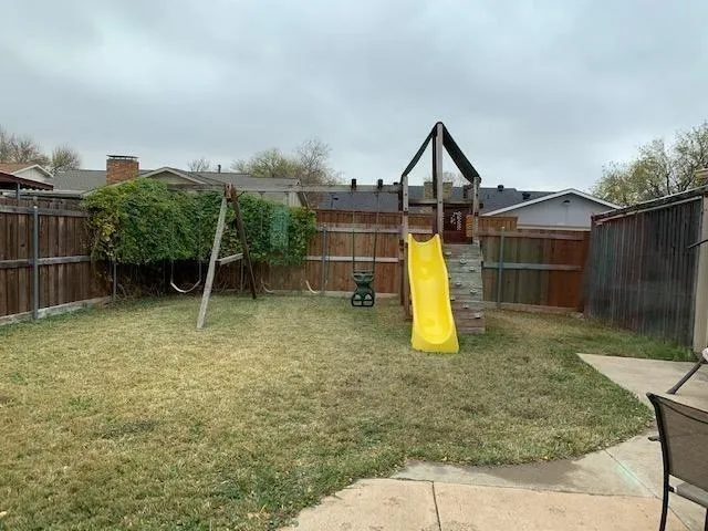 a backyard of a house with potted plants and wooden fence