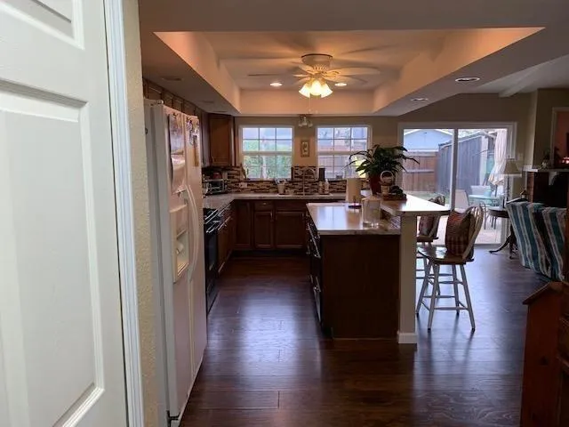 a kitchen with stainless steel appliances granite countertop a refrigerator a stove a sink dishwasher with a dining table and chairs